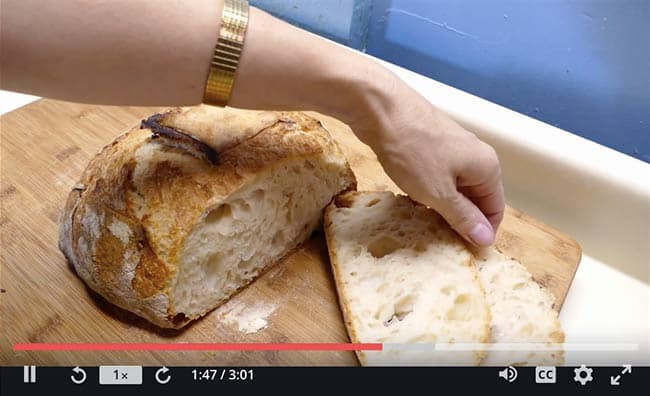 Person baking and slicing sourdough bread. Screenshot from online course "Sourdough Bread Baking 101" on Udemy. Brief course overview.